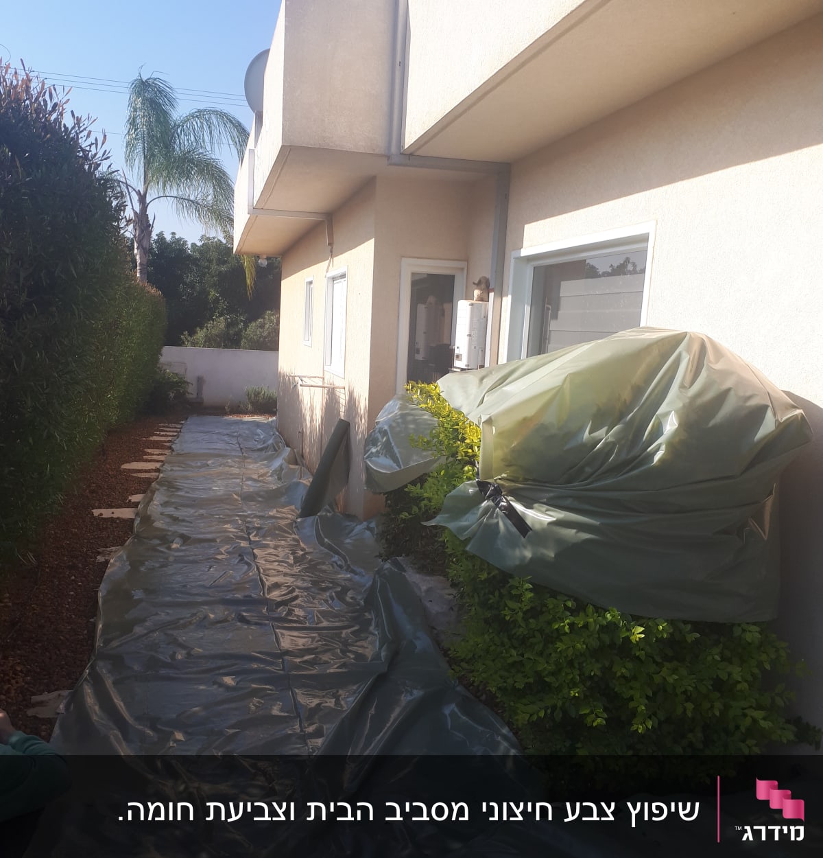 יריעות פלסטיק ירוקות מכסות שביל ליד בית